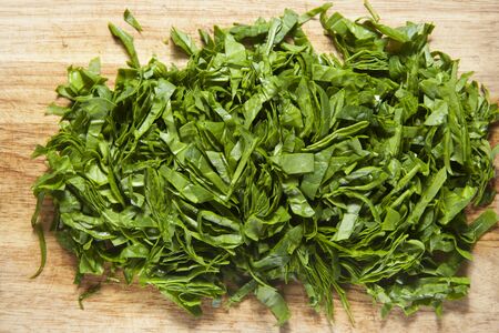 Fresh bright green spinach.Top view. Chopped spinach on a wooden cutting board. 