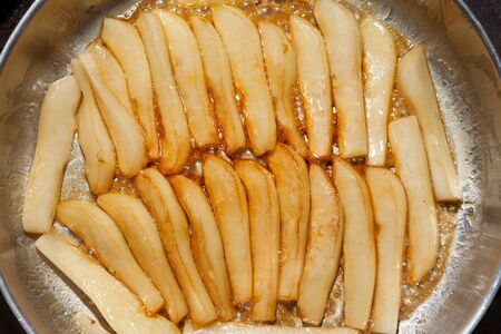Process of caramelization of pears in honey syrup in a pan. Delicious dessert or salad ingredient....