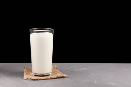 Ayran or kefir in a glass on a dark background. Fermented milk ayran. Milk diet for weight loss. Selective focus. Place for text.の写真素材