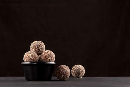 Healthy homemade sweets. Fitness snack. Energy balls made of dates, apricots, almonds, pine nuts and prunes, with honey.の写真素材