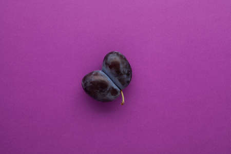 Ripe ugly plum or grown together prunes on a lilac background. Place for text.の写真素材