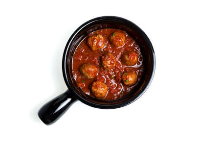 Beef meatballs with tomato sauce in a dark ceramic skillet or serving plate with a handle. Light background, space for copying. Top view.の写真素材