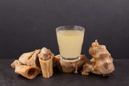 Bone broth in glass. Dark background, copy space. Beef bones contain natural collagen, which provides the body with amino acids, which are the building blocks of proteins.の写真素材