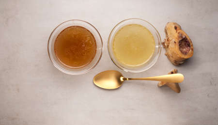 Two types of bone broth in glass bowls. Top view, copy space. Beef bones are a source of natural collagen, which is useful for joints and provides the body with essential amino acids.の写真素材
