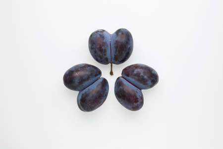Ugly prunes. Three double plums fused together on a light background. Flat lay, top view, copy space. Concept - Food waste reduction. Using in cooking imperfect products.の写真素材