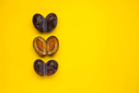 Fused fruits. Whole double prunes and half. Ugly fruits on a yellow background with copy space. Selective focus, copy space. Concept - Food waste reduction. Using in cooking imperfect products.の写真素材
