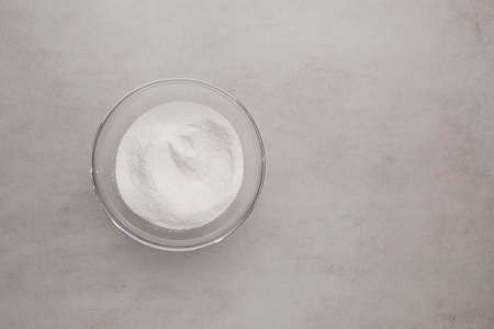 Collagen powder in bowl on stone background. Extra protein intake. Natural beauty and health supplement for skin, bones, joints and gut. Plant or fish based. Flat lay, top view, copy space.の写真素材