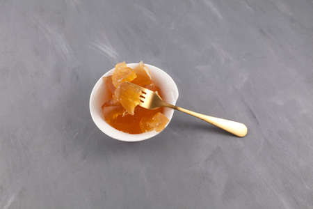 Congealed jelly-like homemade beef bone broth with natural collagen on white bowl on a gray background. Top view, copy space.の写真素材