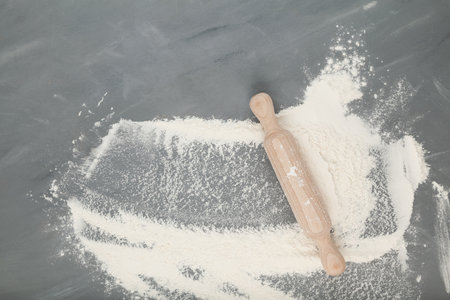 Flour and wooden rolling pin on a gray background, baking ingredients. Top view, copy space.の写真素材