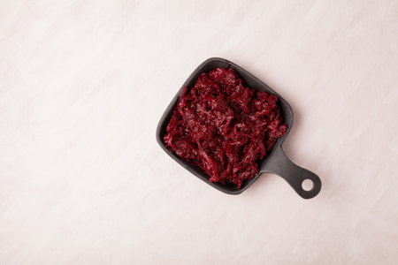 Fried beetroot in a metal pan, top view. Ingredient for borscht or vegetarian salad. Place for text.の写真素材