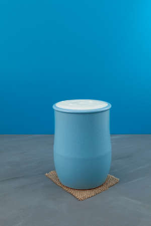 Turkish drink Ayran or kefir in a blue ceramic jug. Fermented milk drink. Diet drink for weight loss. Buttermilk from yogurt. Blue background, selective focus, copy space.の写真素材