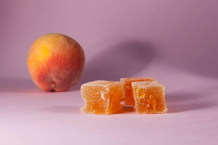 Peach marmalade on pink background with copy space. Close-up, selective focus. Delicious, juicy homemade sweets.の写真素材