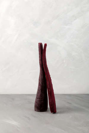 Purple carrots on a light gray background. Concept - Healthy colored dietary vegetables for weight...