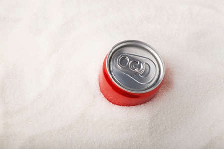 Can of sweet carbonated drink and a lot of sugar. Concept - Excess Sugar in Soda (Fizzy Drinks).の写真素材