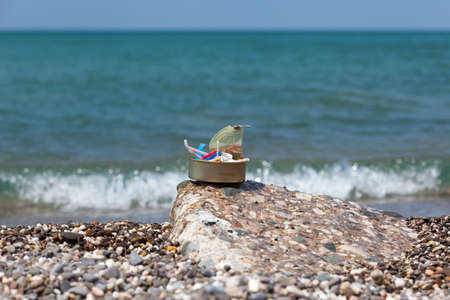 Plastic garbage collected on the seashore in tin can. Concept - excessive consumption of disposable...