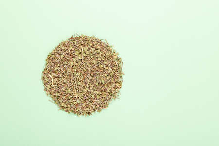 Dried Thyme leaves for making herbal medicinal tea on a light green background.の写真素材