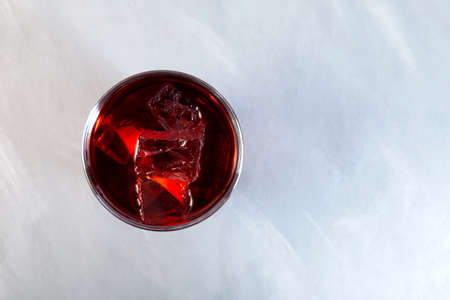 Glass of Americano Alcohol cocktail with red vermouth, bitter, soda water and ice cubes, top view.の写真素材