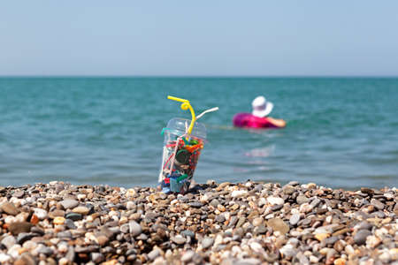 Disposable plastic garbage on the beach. Concept - environmental pollution by household waste.