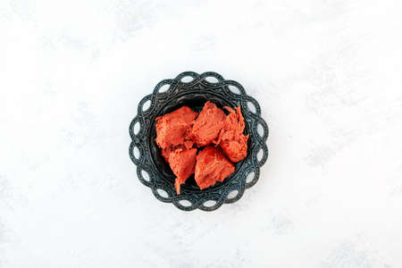 Red plant-based halva with pomegranate flavors in metal serving plate. Oriental sweets. Top view,...