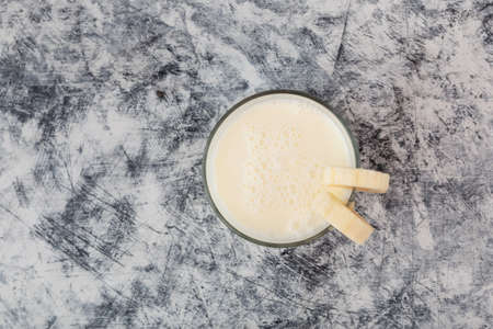 Korean banana milk in glass, top view. Selective focus, copy space. Banana vanilla flavored milk.の写真素材