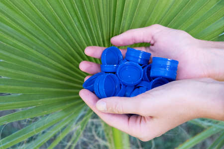 Collecting plastic bottle caps for further processing. Eco trend. Zero waste. Sorting garbage.