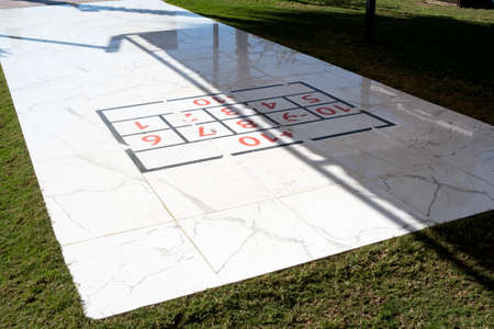 Public outdoor shuffleboard playground. Noon, hard shadows, selective focus. Games and outdoor...