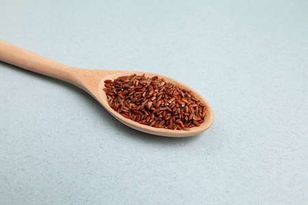 Brown GABA rice in long wooden spoon, close-up. Selective focus, space for text.