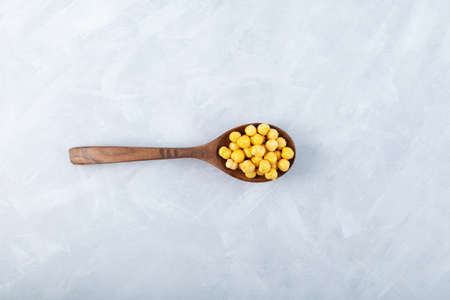 Roasted Chickpea or Leblebi in wooden spoon on gray background. Turkish snack. Selective focus, copy space.の写真素材