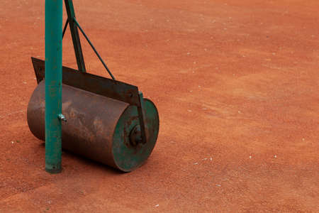 Skating rink filled with water. Heavy hand tool for laying a covering on unpaved tennis court....