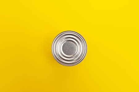 Metal tin can on yellow background, top view. Top cover looks like an abstract target. Design...