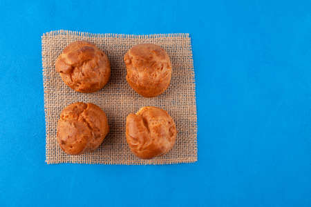 Profiteroles. Golden french buns on blue background, top view. homemade baking.