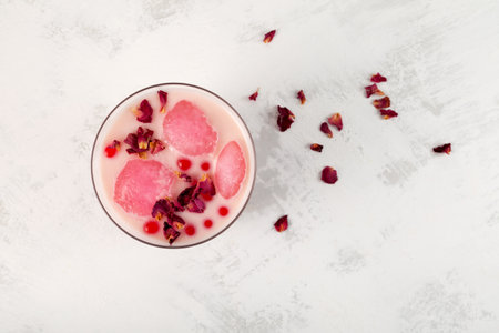 Rose refreshing iced milk cocktail. Iced drink, rose moon milk with fruits ice. Boba drink or bubble tea. Top view, selective focus.の写真素材