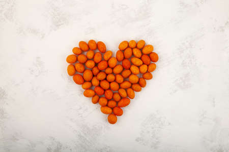 Coated Peanut laid out in the shape of a heart on a gray background. design element. Delicious...
