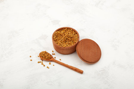 Fenugreek Seeds (Methi Dana) in wooden bowl. Shambhala or helba seeds is traditional Indian...