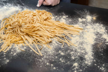 Homemade italian pasta Fettuccine or Pappardelle on dark table, top view. Cooking. selective focus. design element.の写真素材