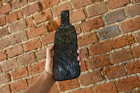 Deformed wine glass bottle after heat treatment. Molten flat bottle. Object for decoration. Design...