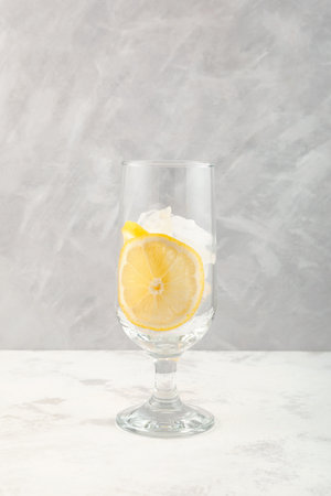 Lemon slices and Ice cubes in drinking glass. Serving set for ice cocktail or other refreshing drink.の写真素材
