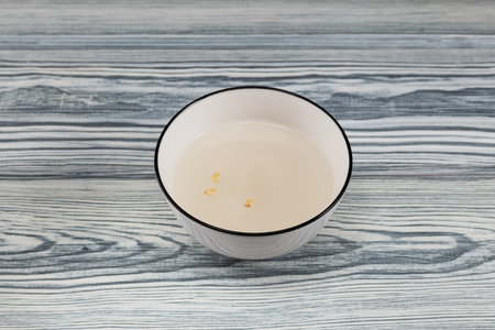 Sikhye - sweet rice drink. Korean afternoon tea in white bowl. Traditional rice beverage on wooden table.の写真素材