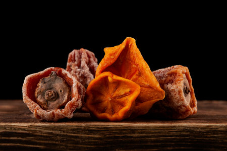 Dried persimmons on dark background. Whole fruits sun-dried persimmon Hoshigaki. Healthy ingredients for traditional fruit punch or tea.の写真素材