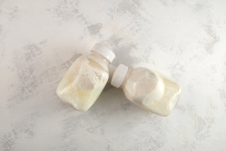 Two bloated swollen bottles with sour milk or expired spoiled dairy product with dangerous bacteria...