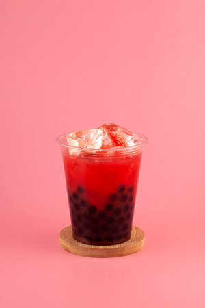 Watermelon boba drink or fruits bubble tea in disposable plastic take away cup. Refreshing ice tea on pink background. Summer iced cocktail with tapioca pearls.の写真素材