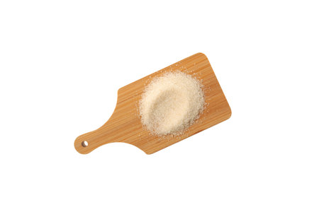 Gelatin granulated or gelatin powder on wooden cutting board isolated on white background. Gelling agent in cooking used in a wide range of food and nonfood products.の写真素材