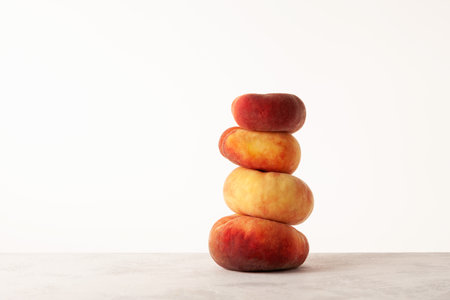 Stack of Fig peaches on the table, side view. Flat donut peaches. Ripe fruits.の写真素材