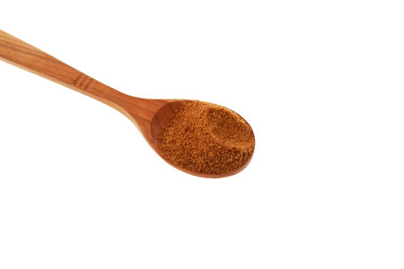 Natural Coconut palm sugar in wooden spoon on white background, top view. design element. Selective focus, close-up. Coco Brown granular sugar.の写真素材