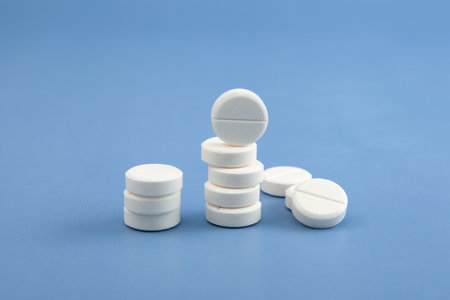 White Placebo pills on blue background. Increased consumption of medications, antidepressants and sedative pills.の写真素材