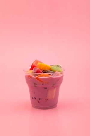 Fruit salad with fruit yogurt in disposable plastic take away cup. Es Campur or Sop Buah. Popular...