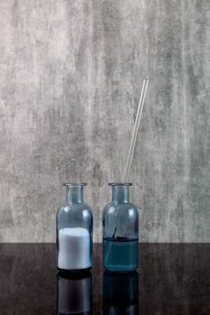 White water-soluble powder in laboratory flask and collagen serum. L-carnitine concentrate in glass bottle. Beauty care, cosmetology product preparation.の写真素材