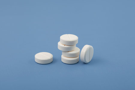 White pills or tablets on blue background. Concept Placebo. Increased consumption of medications, antidepressants and sedative pills.の写真素材