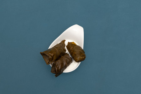 Dolma in white sauce, top view. Stuffed grape leaves with beef or lamb meat. Dolma or Sarma. Mediterranean cuisine.の写真素材