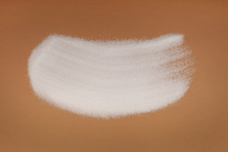 Pile of Sugar substitute Xylitol or birch sugar scattered on brown surface. Food additive E967, sweetener. Excessive consumption may induce laxative effects.の写真素材